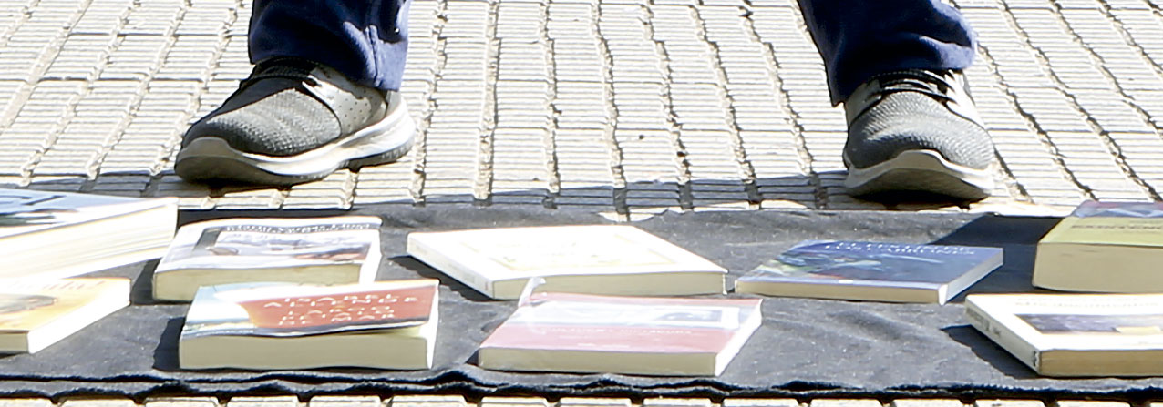 pies de una persona vendiendo libros en la calle, transgrediendo la propiedad intelectual