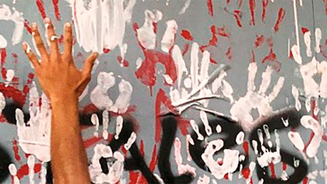 una mano sobre una pared pintadas con manos